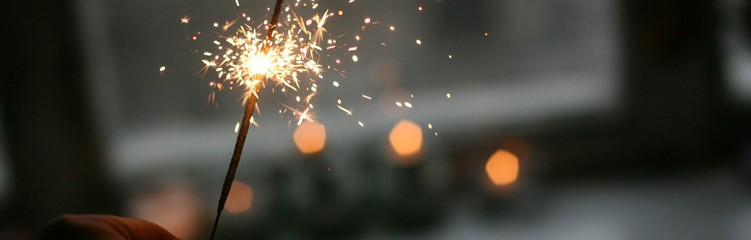 brennende Wunderkerze vor unscharfem Hintergrund